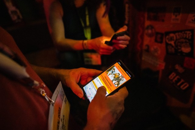 Attendee looking up a band on the SXSW GO app - Photo by Tico Mendoza