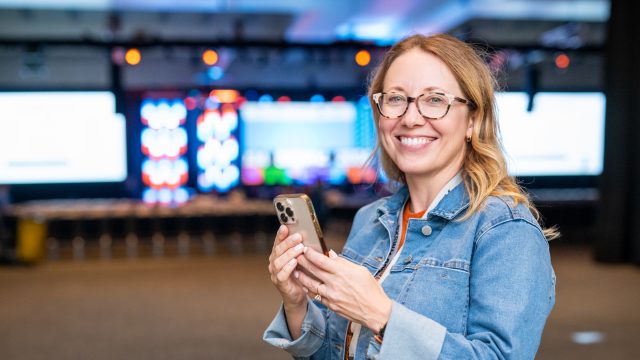 Woman smiling with phone at SXSW 2024.